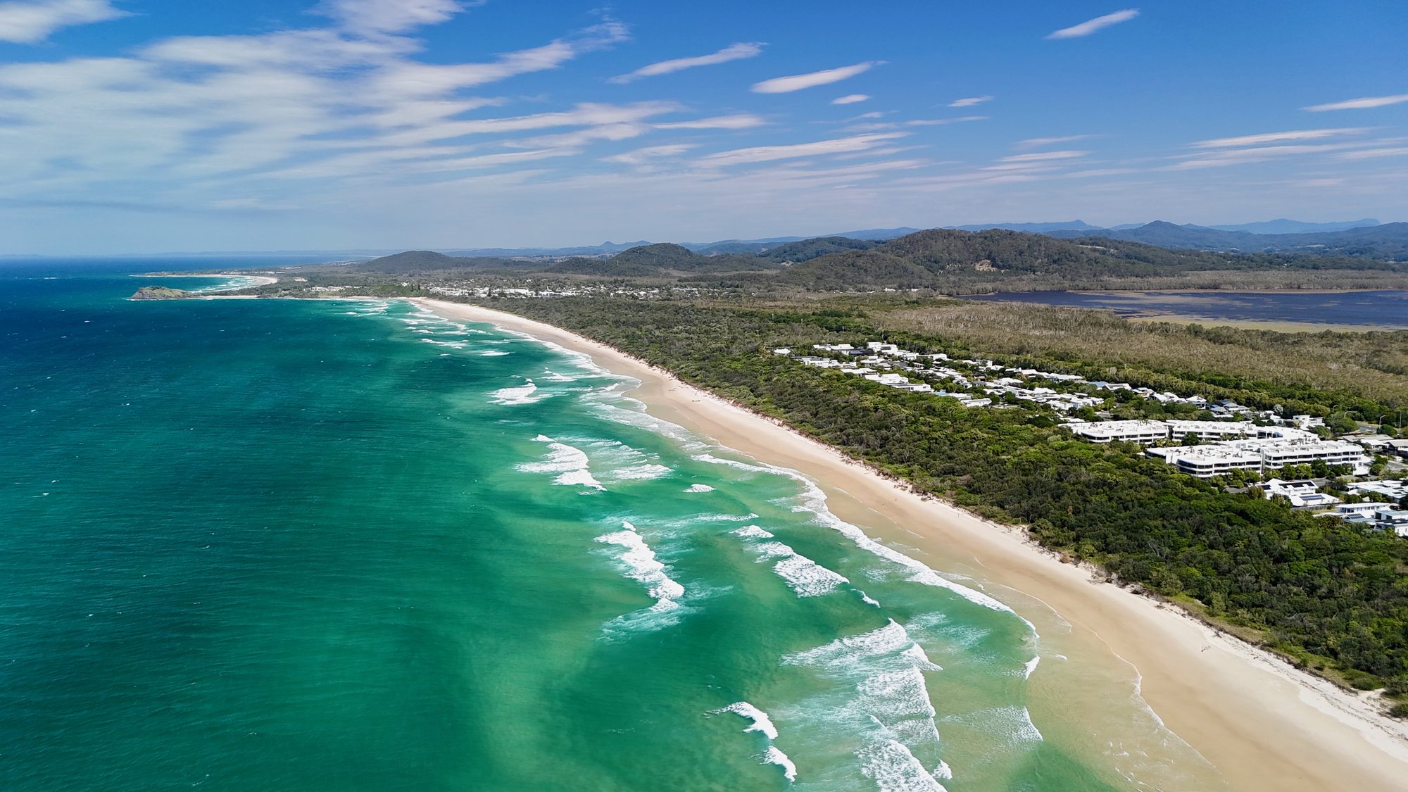 The Tweed Coast from above: surf, a long sandy beach and the hinterland behind
